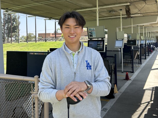 Golfer holding club at driving range